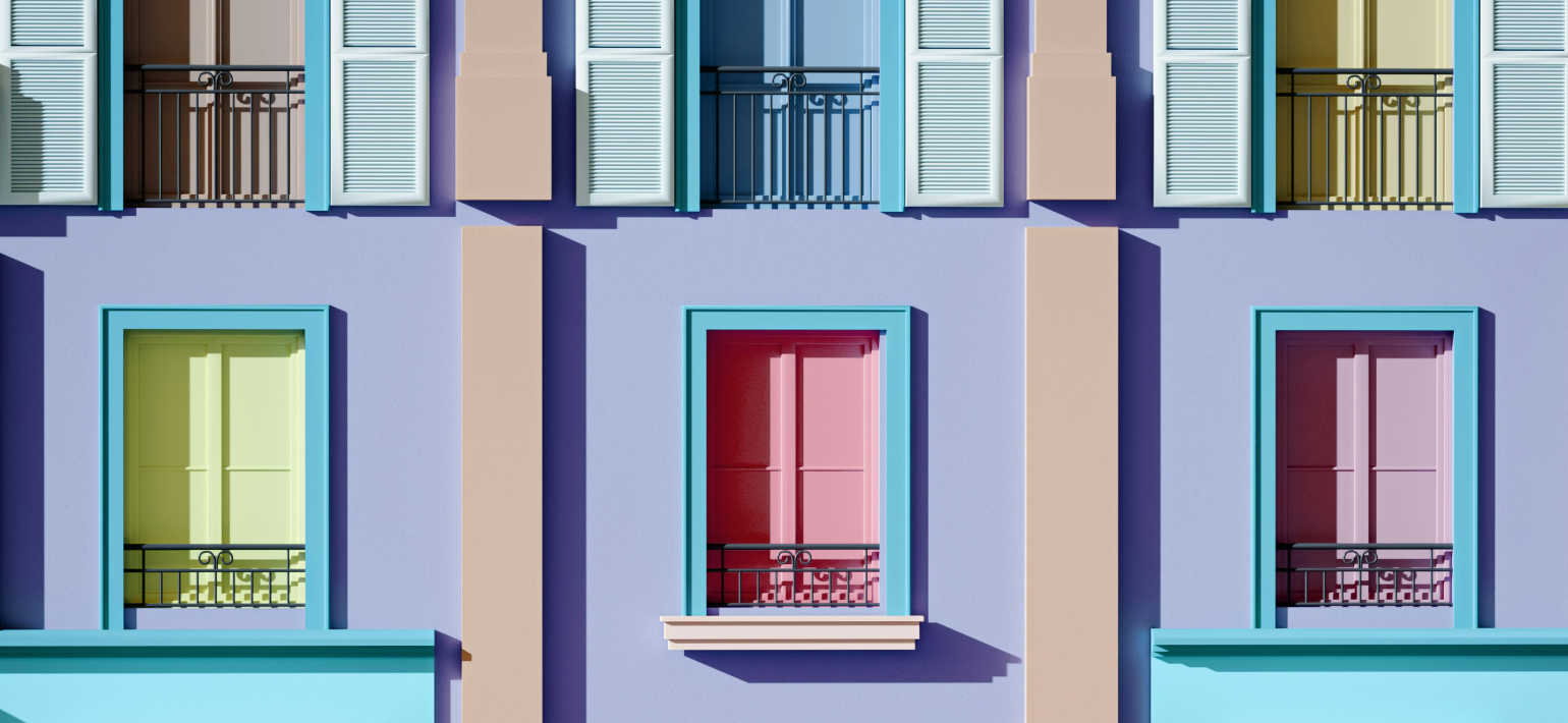 A close-up image of a purple building with colourful windows and white shutters.