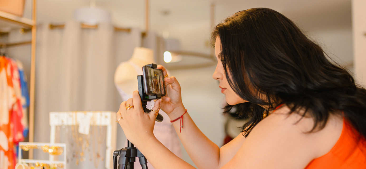 A person taking a photo with her phone on a tripod.