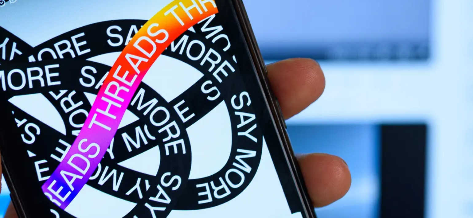 A close-up image of a phone advertising Instagrams latest addition, 'Threads'.
