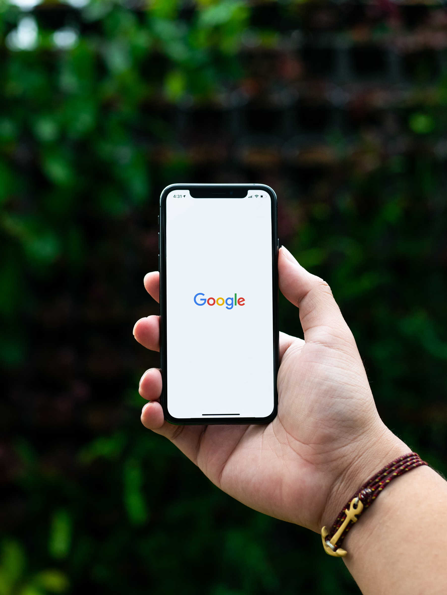 Hand holding smartphone showing Google logo.