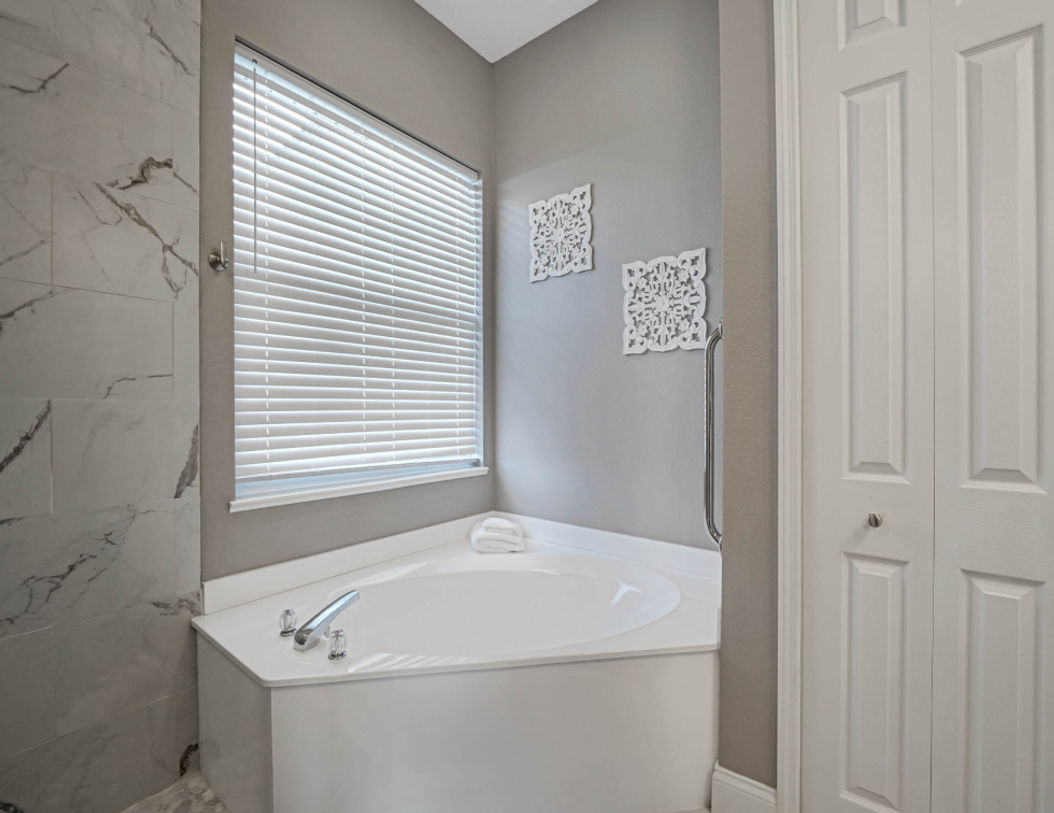 White Bath Tub Beside Beautiful White Blind Curtain