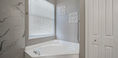 White Bath Tub Beside Beautiful White Blind Curtain