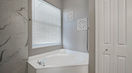 White Bath Tub Beside Beautiful White Blind Curtain