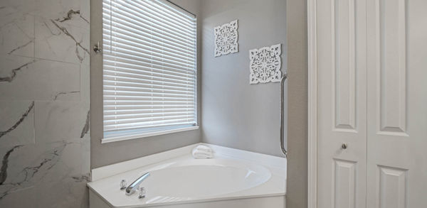 White Bath Tub Beside Beautiful White Blind Curtain