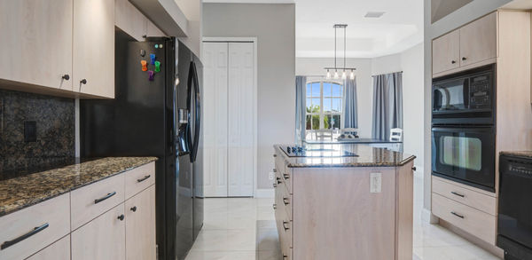 Elegant Kitchen Area With Black Black Refrigerator and Microwave Oven