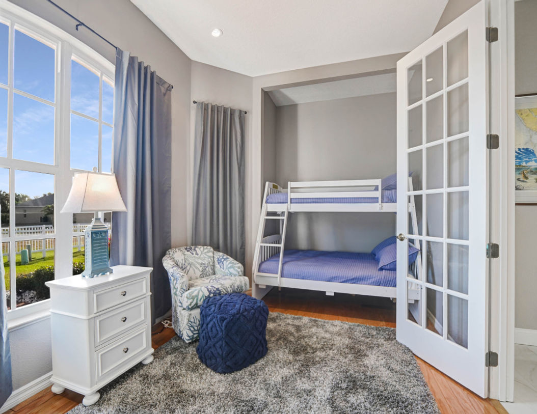 Children’s Bedroom With  Bunk Bed Covered in Stripe Blue Bedding