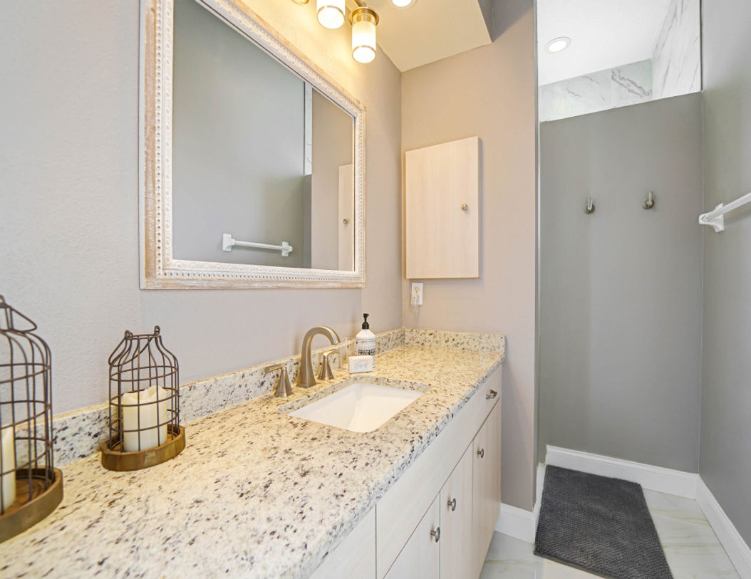 Framed White Mirror in a White and Gray Bathroom 