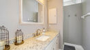 Framed White Mirror in a White and Gray Bathroom 