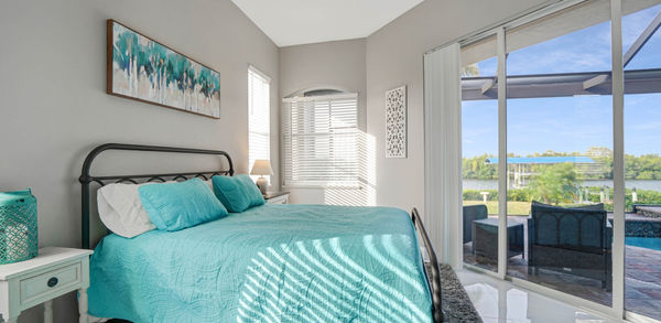 Big Bedroom Covered in Sky Blue Bedding Near Pool Area