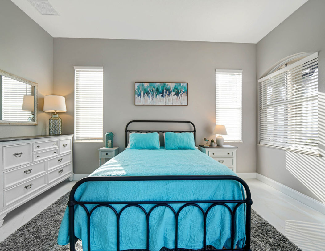 Bedroom With White Blind Curtains and Double Bed Covered in Sky Blue Bedding