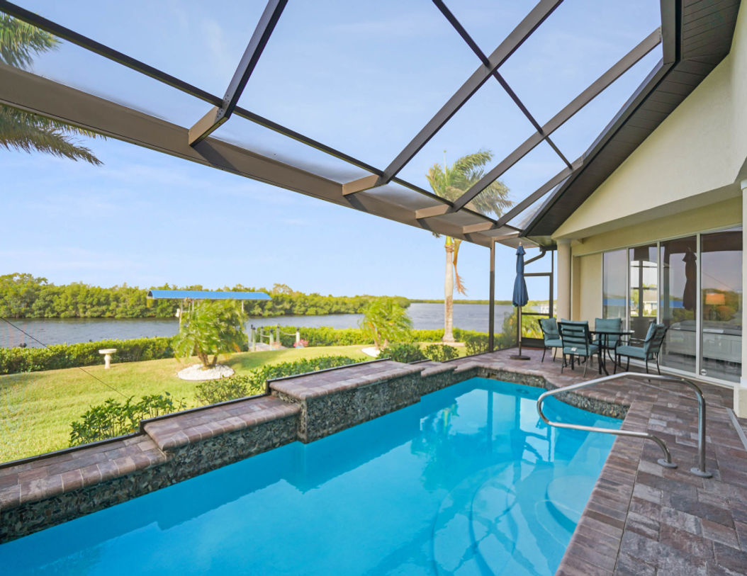 Modern Outdoor Pool Area With Blue Table Set Near Backyard