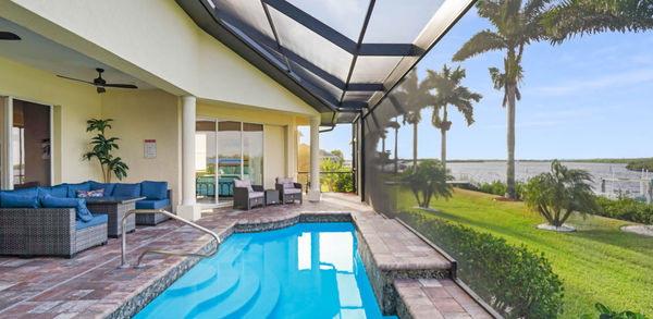 Swimming Pool View With Two Outdoor Chairs and Blue Covered Couch Set