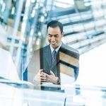 Man in a suit using his phone in a business building