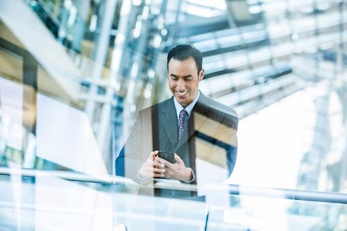 Man in a suit using his phone in a business building