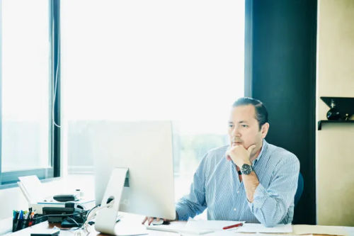 Man in office looking at laptop