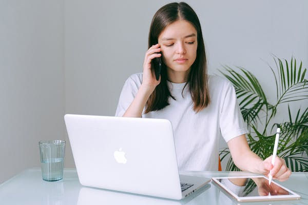 A girl taking customer calls while working on a tablet