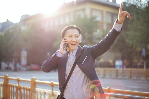 Man on the phone while hailing a cab