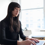 Young woman working on her laptop using 2-factor authentication