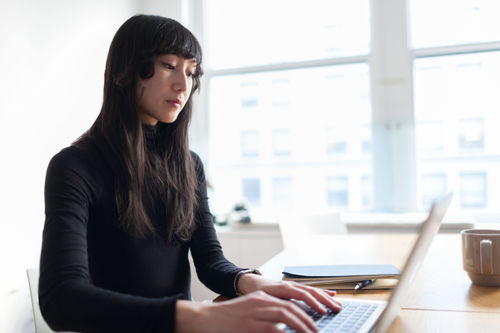 Young woman working on her laptop using 2-factor authentication