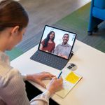 A female employee communicating with business colleagues on a video call using CCaaS tools on a laptop.