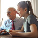 A girl and an old man filling customer experience form on laptop