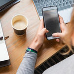 A lady sending an SMS message on her mobile in the office