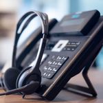 A VoIP phone with a headset on a desk