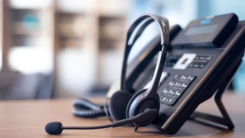 A VoIP phone with a headset on a desk