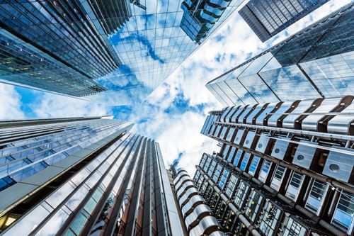 Blue sky and clouds reflected on buildings representing the power of cloud technology