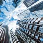 Blue sky and clouds reflected on buildings representing the power of cloud technology