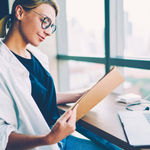 Female healthcare worker reviewing patient file sent securely through 8x8 cloud communications