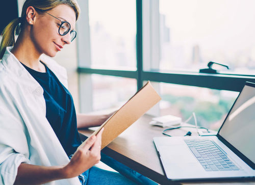 Female healthcare worker reviewing patient file sent securely through 8x8 cloud communications