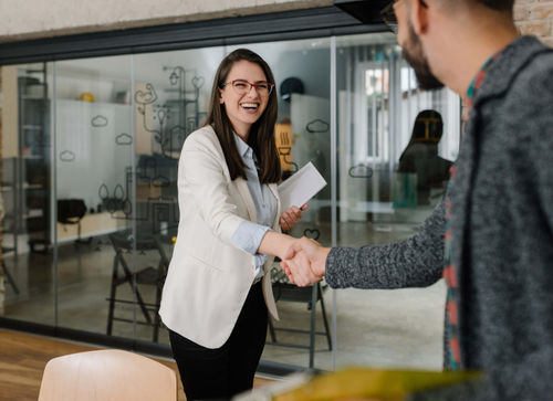 Woman and man shaking hands before conducting an interview for professional services fit