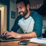 A man searching about 8x8’s partner’s program on his laptop to grow his agency business.