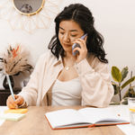 A lady listening to a voice message on the phone in the office