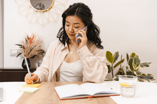 A lady listening to a voice message on the phone in the office