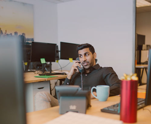 man-using-multi-line-phone-system-at-office.png