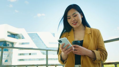 A lady wearing a yellow jacket chatting on WhatsApp