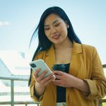 A lady wearing a yellow jacket chatting on WhatsApp