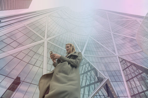 Woman outside her building accessing VoIP features from her mobile phone