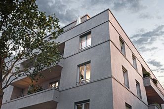 Grünflächen und Bäume: Der Blick auf das Gebäude mit Loggien