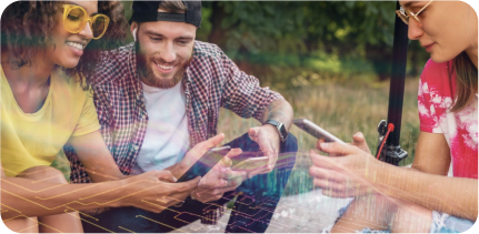 A group of happy young people are sitting and looking at their smartphones.