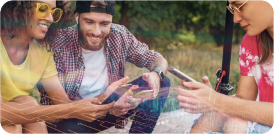 A group of happy young people are sitting and looking at their smartphones.