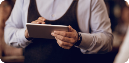 A waiter is working with a tablet.