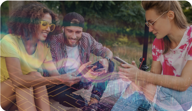A group of happy young people are sitting and looking at their smartphones.