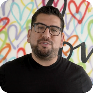 A guy wears glasses and looks at the camera while talking.