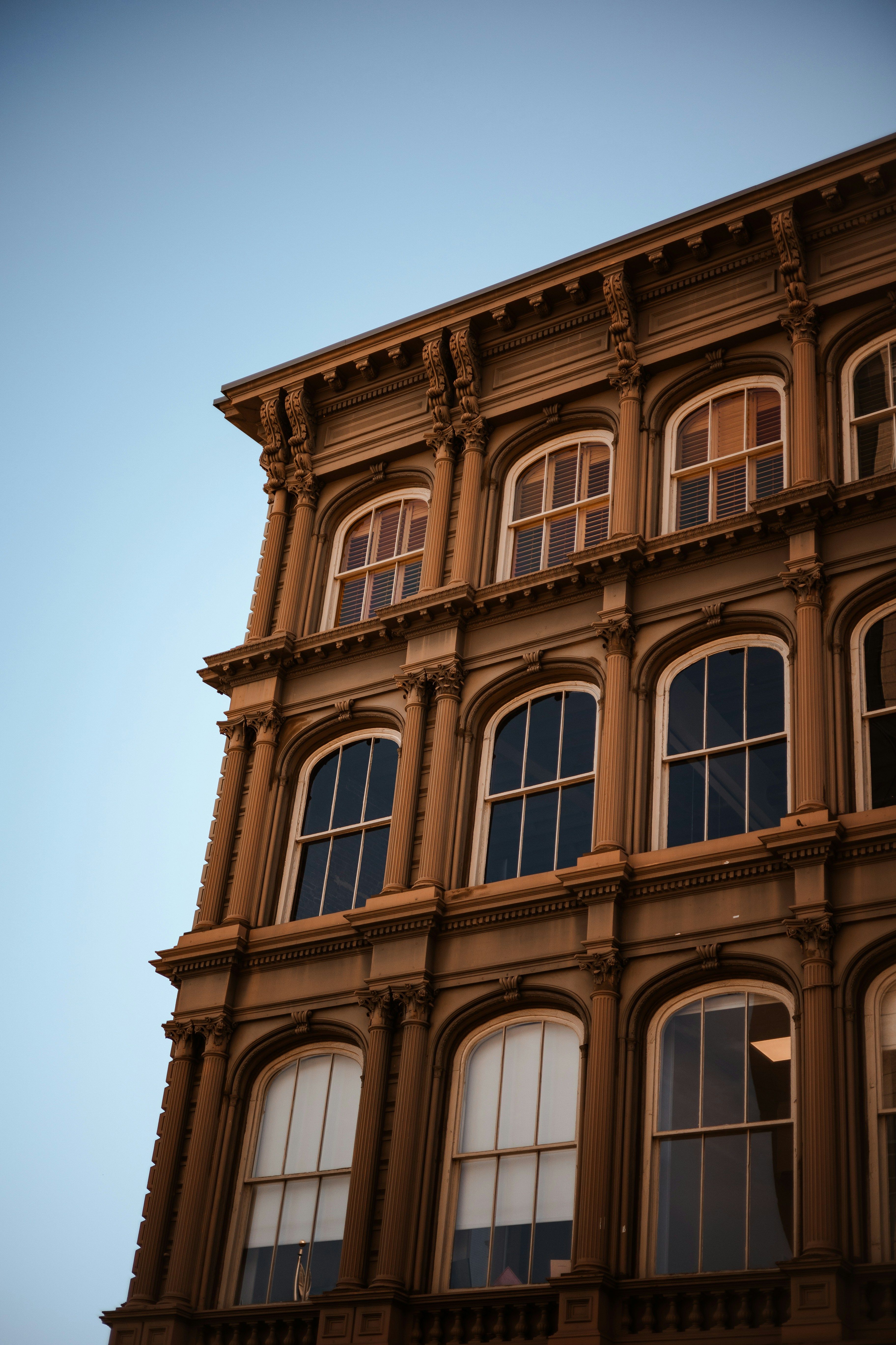 Close-up architectural detail of a historic red brick building in downtown Mobile, AL with ornate arched windows and terracotta faade