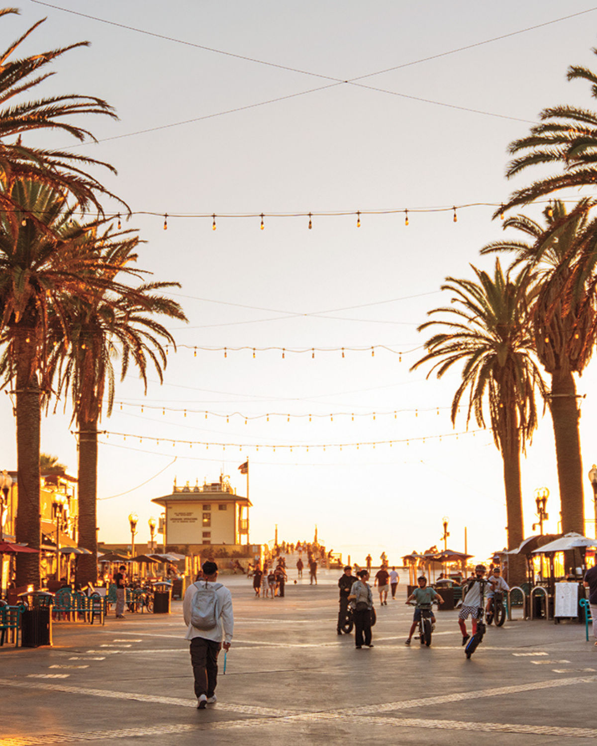 The Hermosa Beach Pier extending into the Pacific with sandy shoreline and beachgoers along the coast.