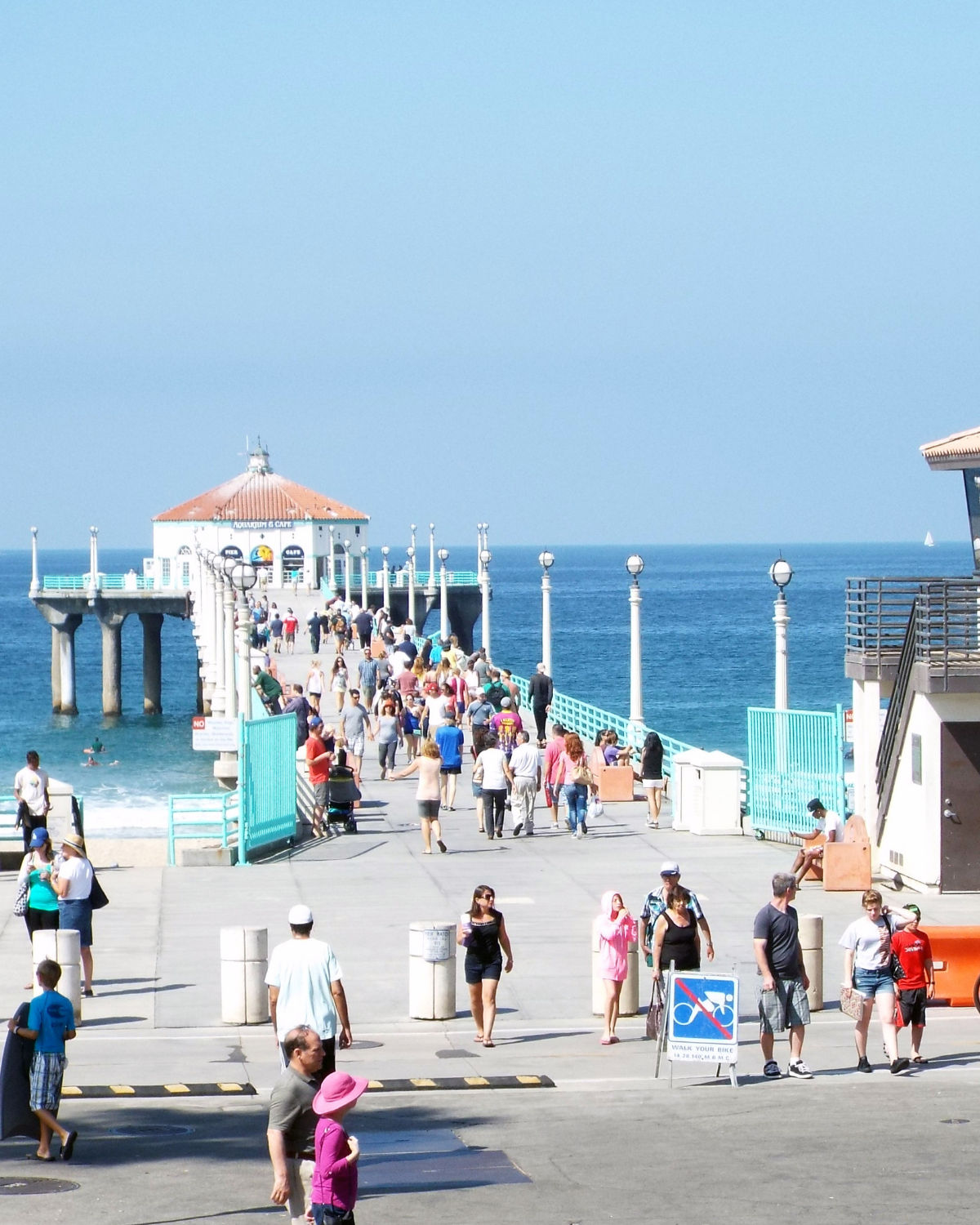 The Manhattan Beach Pier extending into the Pacific with the Roundhouse at the end and waves below.