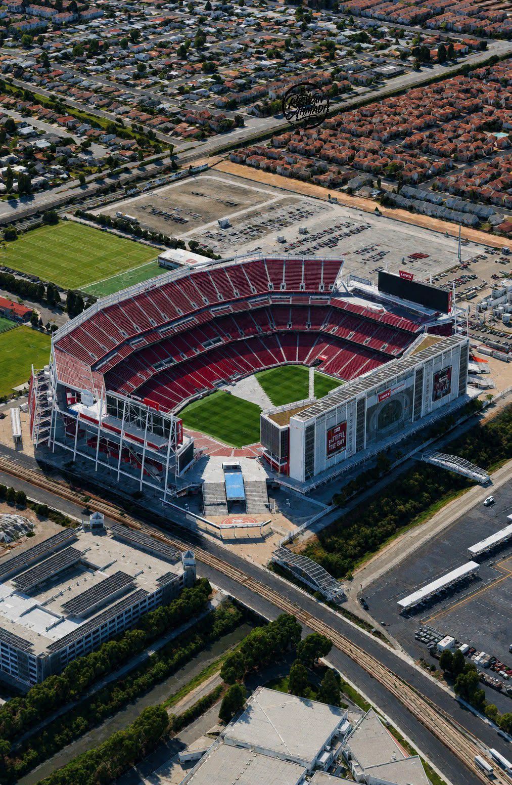 Aerial view of Levi’s Stadium in Santa Clara, California, featuring the football field, red stadium seating, surrounding neighborhoods, roads, and Silicon Valley landscape.